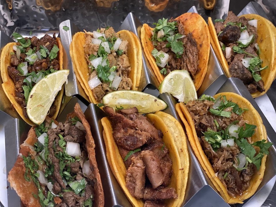 Outdoor seating beside a roadside taqueria.